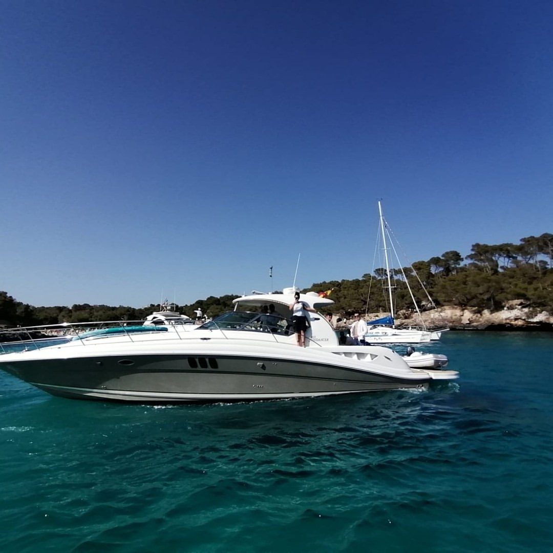 Sea Ray 455 Sundancer fondeado en una cala de aguas turquesa cerca de Santanyí, Mallorca